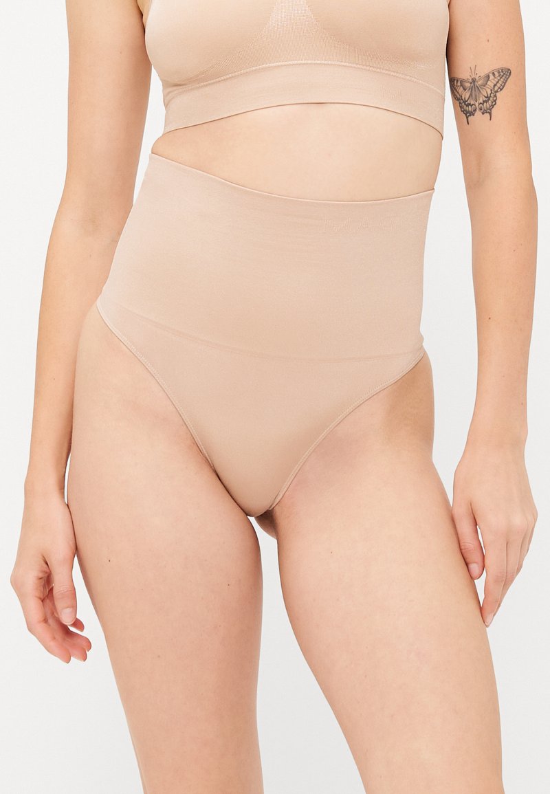 Beige, hochtaillierte Unterwäsche aus einem glatten, dehnbaren Material. Einfaches Design ohne sichtbare Nähte, das vollständige Abdeckung und Komfort bietet.
