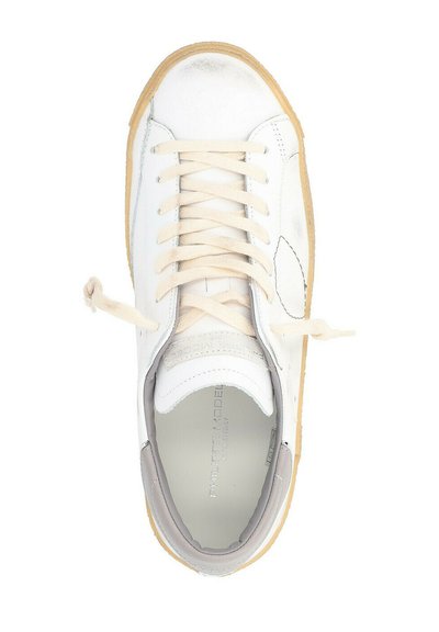 Sneaker bianco con tomaia in pelle liscia, lacci beige, accenti grigi e suola in gomma testurizzata. Presenta un design della punta arrotondata.