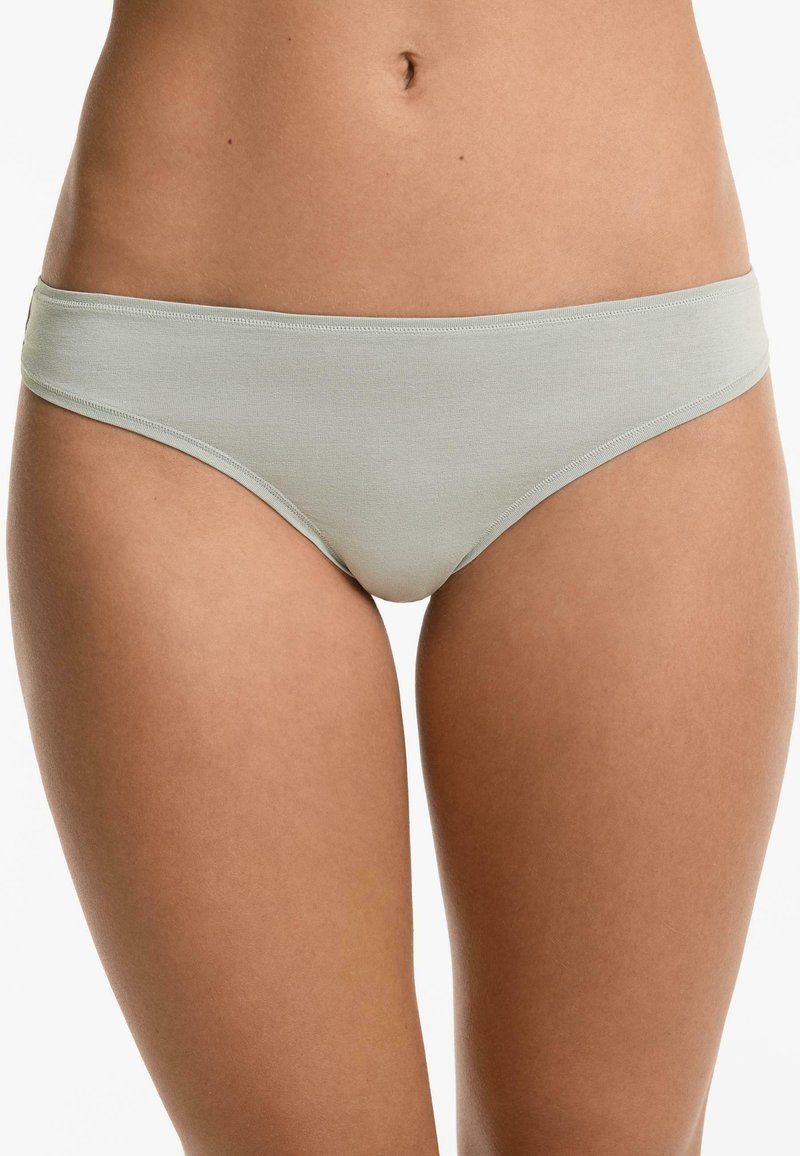 Lichtgroene katoenen bikini slipjes met een gladde textuur en een laag uitgesneden ontwerp. Voorzien van een zachte tailleband en minimale stikselaccenten.