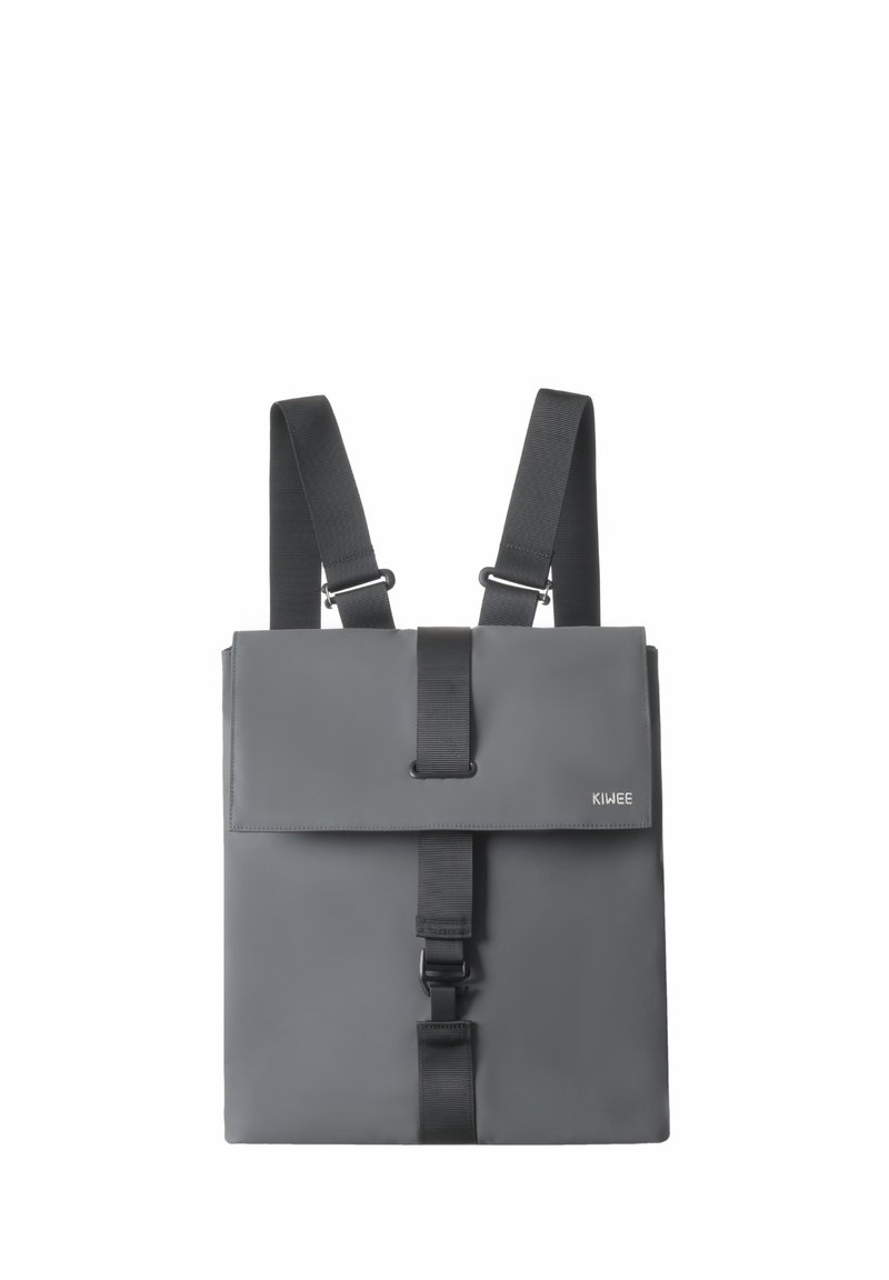 Sac à dos gris avec des bretelles noires réglables, une boucle de sécurité à l'avant et un rabat de fermeture. Fabriqué en matériau lisse et durable. Design minimaliste.