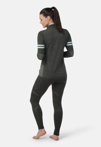 Mørkegrå atletisk langærmet top med stribede detaljer, kombineret med mørke leggings med strukturerede mønstre og en tætsiddende pasform.