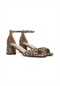 Sandales à talons léopard avec une bride de cheville, bout ouvert et talon block. Le matériau semble doux avec une texture à motifs.