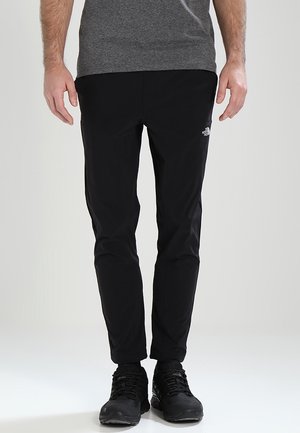 Schwarze Outdoor-Hose mit schlanker Passform, hergestellt aus leichtem Material, mit einem kleinen weißen Logo am linken Oberschenkel.