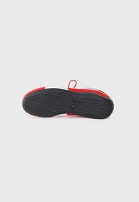 Scarpa sportiva rossa con suola in gomma nera, caratterizzata da motivi testurizzati per una presa sicura e un accento bianco sul tallone. Include un occhiello per una facile calzata.