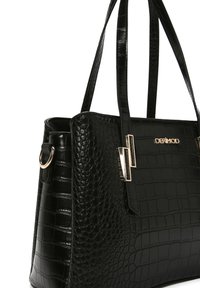 Zwarte tote bag met krokodillenpatroon en glanzende textuur, dubbele handvatten, gouden hardwareaccenten en het merkembleem aan de voorkant.