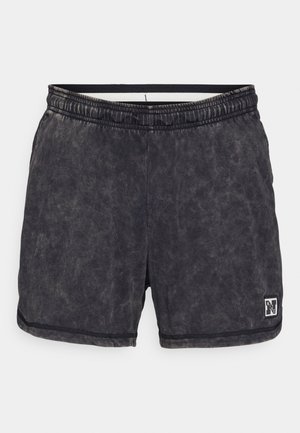 Black, textured shorts made of a soft material. Features an elastic waistband and a small logo patch on the lower right.