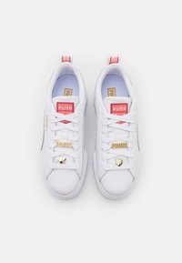 Białe trampki z fakturowaną skórzaną cholewą, różowymi akcentami na języku, złotymi detalami i serduszkiem na sznurówkach.