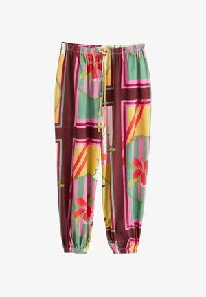 Pantalones de corte holgado con cintura y puños elásticos, con patrones geométricos y florales coloridos en tonos verdes, amarillos, rosas, rojos y marrones.