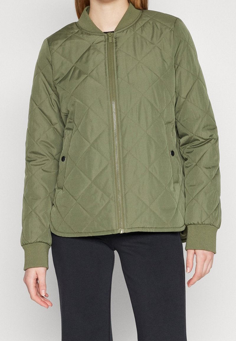 Quiltad olivgrön jacka med rund krage, frontdragkedja och sidofickor. Har ribbade ärmslut och en avslappnad passform.