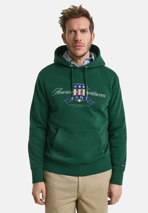 Dunkelgrüner Kapuzenpullover mit einer Vordertasche, verziert mit einem bedruckten Logo und Textdesign in Blau, Weiß und Rot. Rippbündchen an den Ärmeln und am Saum.