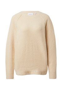 Jasnobeżowy sweter o miękkim, teksturowanym wykończeniu. Posiada okrągły dekolt, długie rękawy oraz ściągacze na dole i na końcach rękawów.