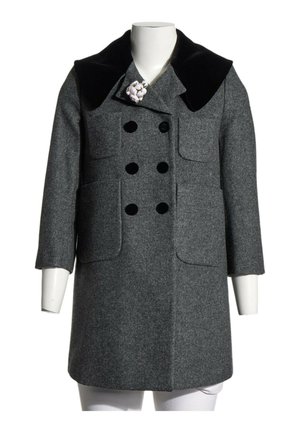Manteau en laine gris à double boutonnage avec col en velours noir, deux poches avant et une épingle florale blanche sur le revers gauche, présenté sur un mannequin.
