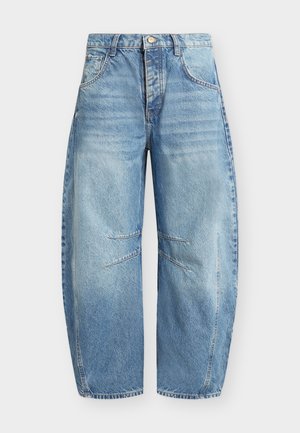 Jean en denim bleu clair à jambes larges avec fermeture à boutons à l'avant, poches avant courbées et détails cousus au niveau des genoux.