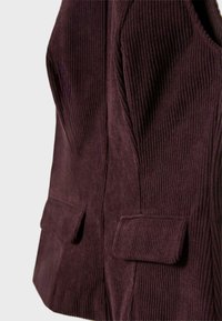 Gilet in corduroy bordeaux con texture a coste, dotato di due tasche frontali e dal design aderente, che mette in evidenza cuciture strutturate e una finitura liscia.