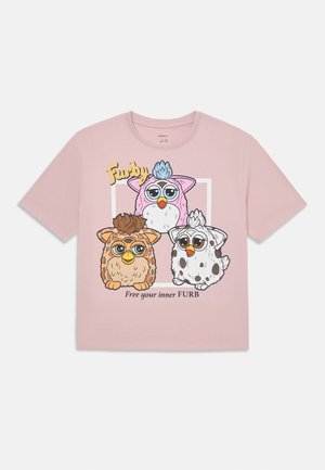 Šviesiai rožinė medvilninė marškinėliai su animaciniais Furby personažais rudos, rožinės ir baltos spalvos. Po piešinuku yra užrašas "Išlaisvink savo vidinį FURB".