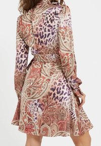 Robe à manches longues en tissu soyeux, présentant un motif paisley et imprimé animalier dans des tons de violet, rose et orange avec une ceinture à la taille.