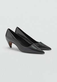 Talons en cuir verni noir avec un bout pointu et un talon conique en bois brun de 5 cm. Texture lisse et design épuré et minimaliste.