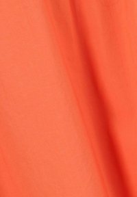 Tissu orange vif avec une texture lisse, présentant des plis et des drapés, indiquant une composition légère adaptée à un usage décontracté.