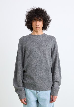 Suéter gris con cuello redondo, mangas de corte holgado y dobladillo acanalado. Fabricado en material suave y texturizado, presenta un pequeño detalle de logo.