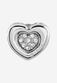 Srebrny wisiorek w kształcie serca z mniejszym sercem ozdobionym cyrkoniami, z wybitym słowem "GUESS" na jednej stronie. Gładka faktura i błyszczące wykończenie.