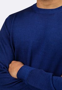Maglione a maniche lunghe bleu navy in maglia testurizzata con scollatura a girocollo e polsini a coste, che presenta una vestibilità aderente e una superficie liscia.