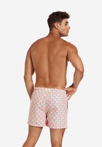 Simshorts i rosa med ett diamantmönster i blått och vitt. Har en elastisk midja och en liten logotyp-patch bak.