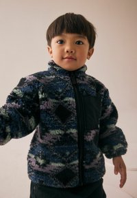 Veste en polaire zippée aux motifs bleus, violets et verts ; dotée d'une poche poitrine noire et d'un col montant ; tissu doux et texturé.