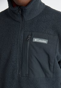 Dark grey fleece jacket with zippered chest pocket and Columbia logo patch on the front.