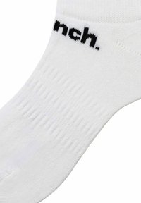 Weisse Baumwollsocken mit einem strukturierten Design und einem schwarzen Logo mit der Aufschrift "nch." nahe dem Bündchen. Glattes Material mit verstärkter Spitze und Ferse.
