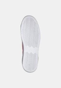 Sole della scarpa con un motivo a spina di pesce, principalmente in gomma bianca con accenti di rosso e grigio sui lati. Superficie texture per una migliore aderenza.