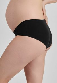 Černé těhotenské kalhotky, hladká tkanina, střední výška pasu, přiléhavý střih, zvýrazňuje zaoblené bříško, minimální švy pro pohodlí.