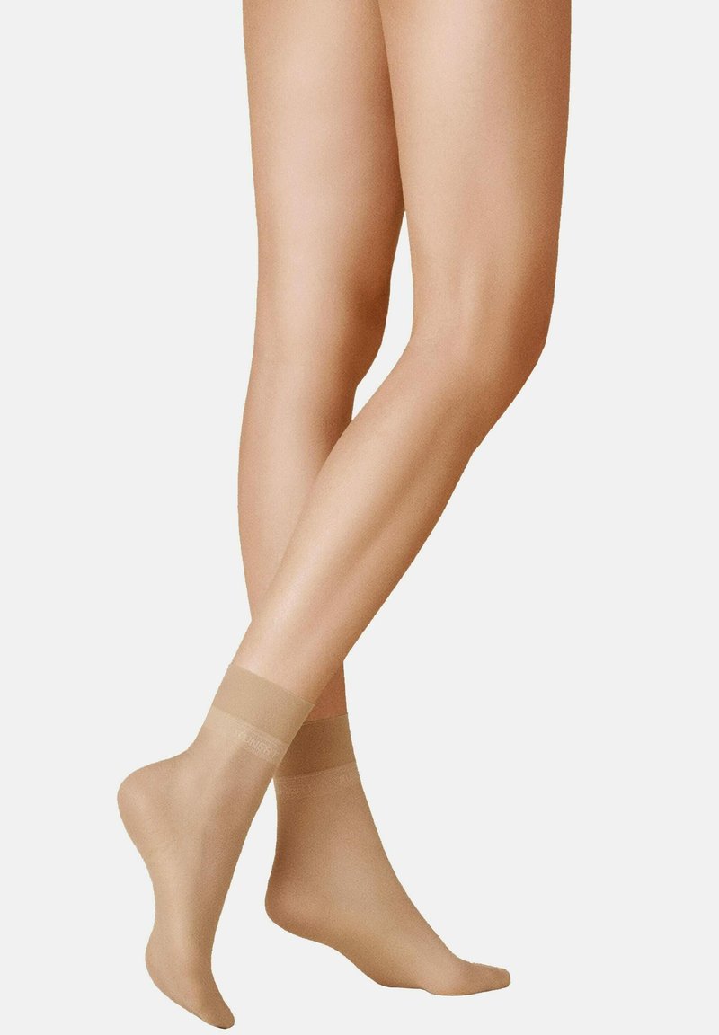 Beige Knöchelsocken aus transparentem Material mit einer weichen, glatten Textur. Verfügen über ein breites elastisches Band am oberen Ende für einen sicheren Sitz.