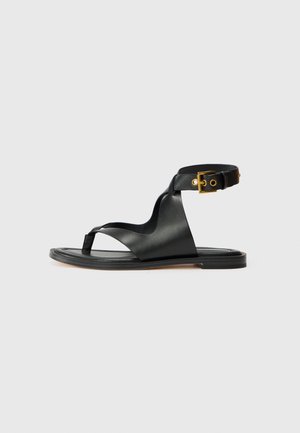 Zwarte leren sandaal met een elegante uitstraling, open teen en verstelbare enkelband met goudkleurige hardware. Platte zool.