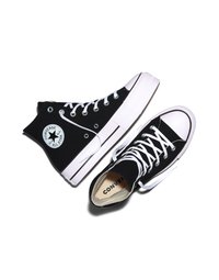 Czarne trampki Converse All Star za kostkę z białymi sznurowadłami i gumową podeszwą, jedno but stoi pionowo, drugie leży na boku.