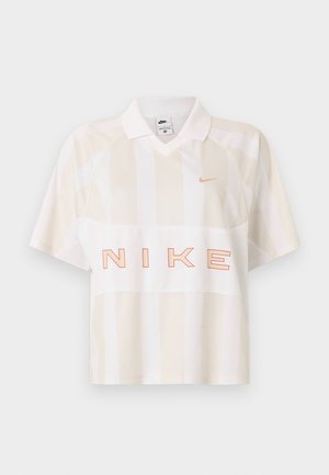 Polo à manches courtes rayé blanc et beige de Nike avec col, petit logo swoosh sur la poitrine et grand texte "NIKE" en contours sur le devant.