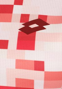 Tela de patrón rojo y rosa con diseño de cuadrícula; presenta un logotipo rojo oscuro centrado en la prenda; se puede ver la textura de malla.
