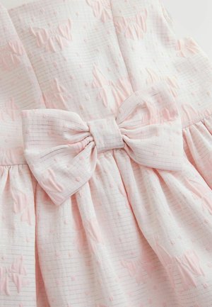 Lichtroze gestructureerde stof met verhoogde vlindermotieven en een grote siervlecht ter hoogte van de taille van een jurk.