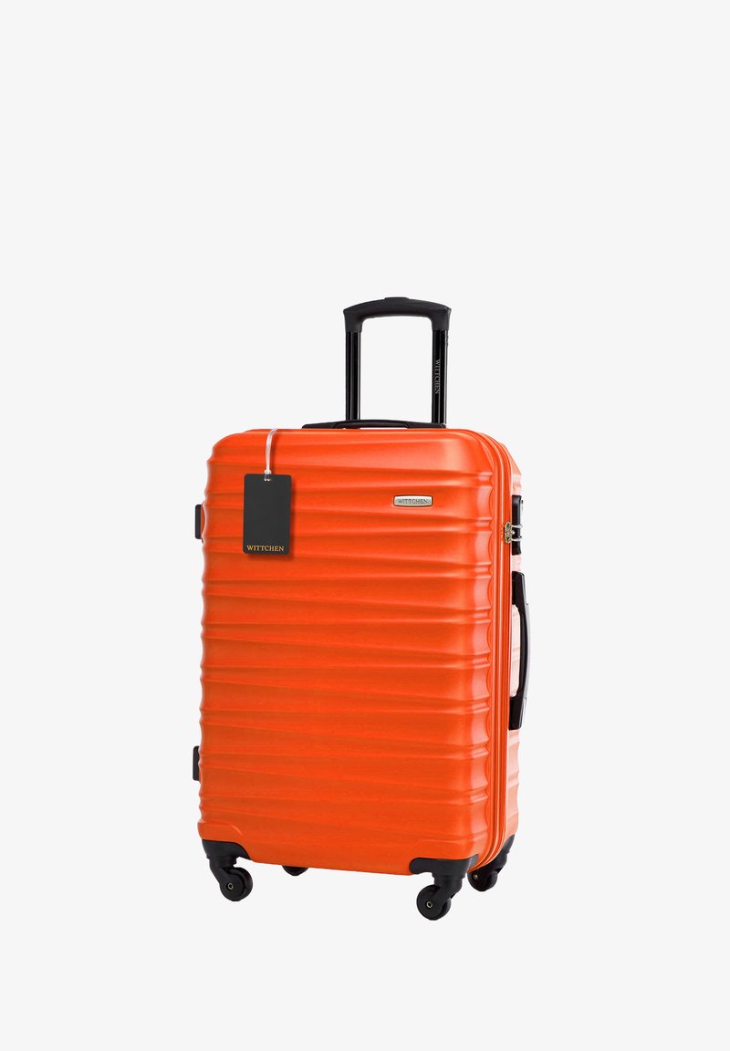 Valigia rigida di un brillante arancione con una texture a righe, manico nero retrattile e quattro ruote per la mobilità. Etichetta attaccata.
