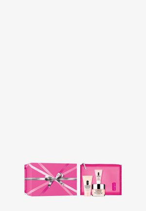 Caja de regalo rosa de Clinique con cinta plateada, que contiene tres productos para el cuidado de la piel y un estuche rosa a juego con cremallera.