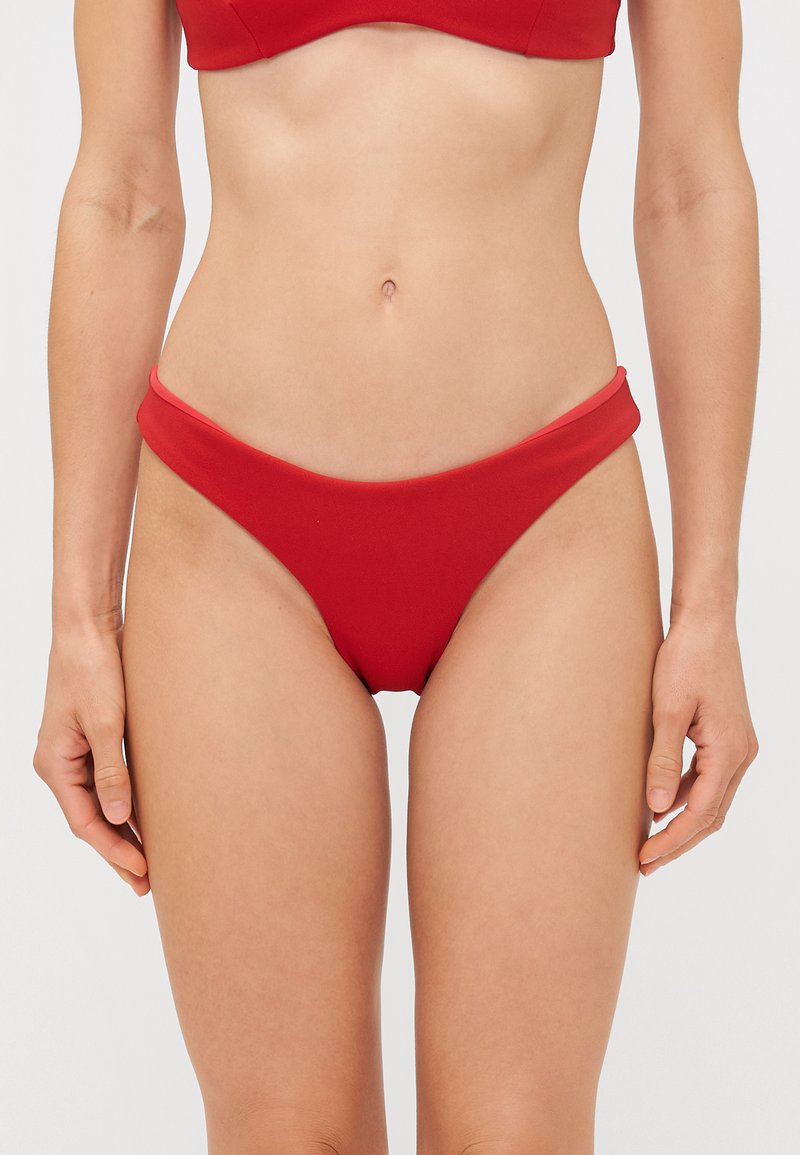 Sarkans bikini apakšējais daļa ar gludu tekstūru, zemu jostas līniju un platu jostu. Vienkārša, vienkrāsaina ar minimālu detalizāciju.