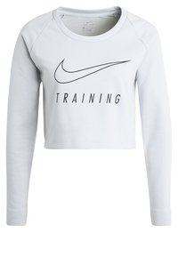 Sweatshirt court bleu clair à manches longues, arborant un logo Nike swoosh noir et le mot "TRAINING" en caractères gras. Texture de tissu lisse.