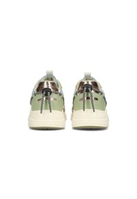 Sneaker con una toma superiore verde pallido, accenti metallici, lacci neri e bianchi e una suola spessa color crema. Dettagli testurizzati sul tallone.
