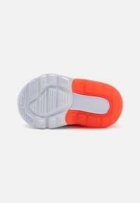 Semelle de chaussure avec une base translucide blanche et des accents orange, surface texturée et différentes sections en caoutchouc moulé pour une meilleure adhérence.