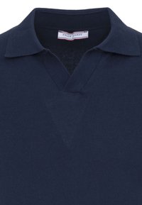 Polo en maille bleu marine avec un col doux et une encolure en V, affichant une étiquette "Felix Hardy" à l'intérieur du col.
