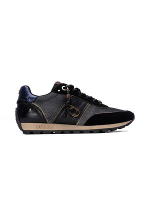 Zapatilla negra y gris con paneles texturizados, borla decorativa en los cordones, suela beige y logo "Carmela" en el lateral.