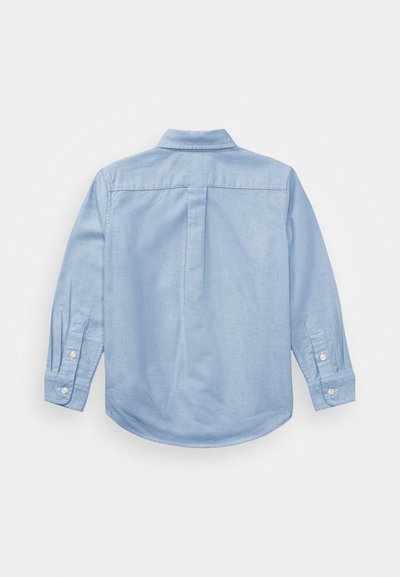 Camisa de manga larga de color azul claro, fabricada con tejido suave, que presenta un cuello clásico y puños con botones, con un dobladillo curvado y detalles de pliegue en la parte posterior.
