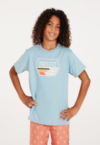 Lichtblauw t-shirt met korte mouwen en een ronde halslijn, voorzien van een grafisch logo in wit, oranje en geel. Glad katoen.