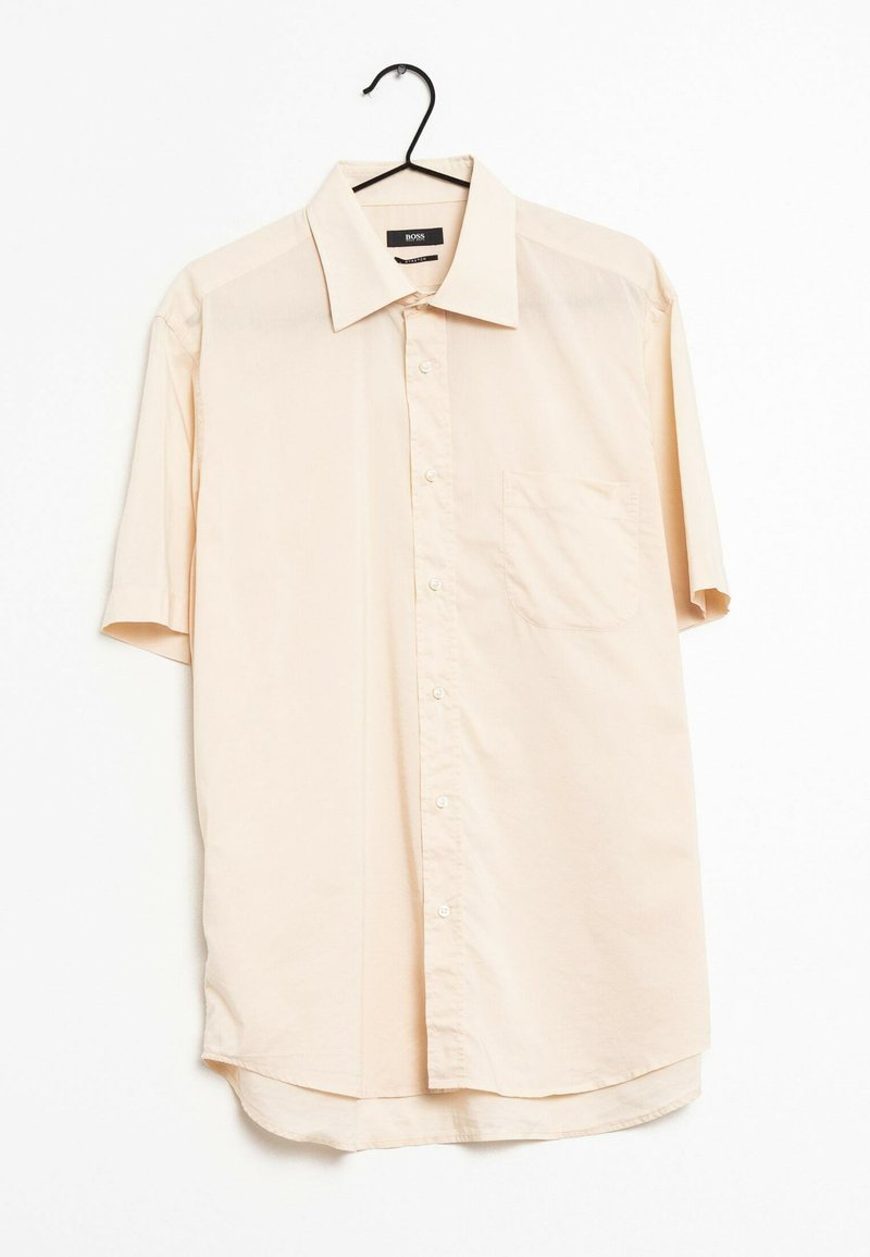 Kortärmad, knappen-up skjorta i ljusbeige tyg. Har en spetsig krage, en bröstficka och en böjd nederkant.