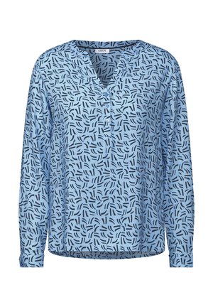 Lichtblauwe blouse met lange mouwen en een V-hals, voorzien van een herhalend abstract zwart patroon en drie knopen bij de halslijn. Zachte stof.