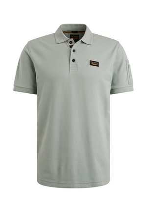 Svijetlozelena polo majica od pamuka. Ima tri gumba na prednjem dijelu, mali logotip na prsima i kratke rukave. Glatka tekstura.